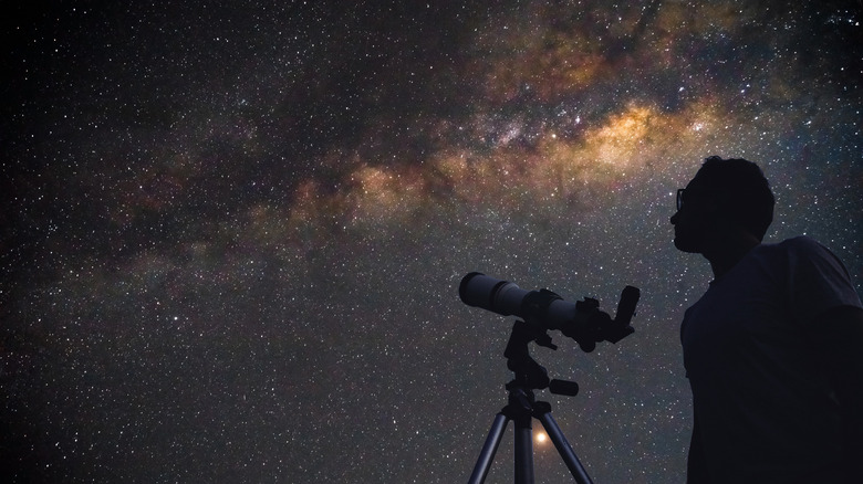 Person looking at the sky with a telescope