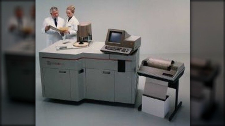 Clinicians looking at charts by a big machine