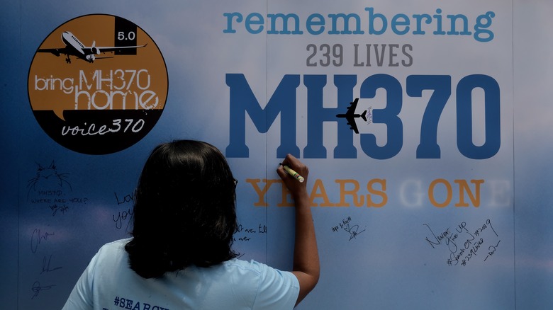 person signing MH370 memorial sign