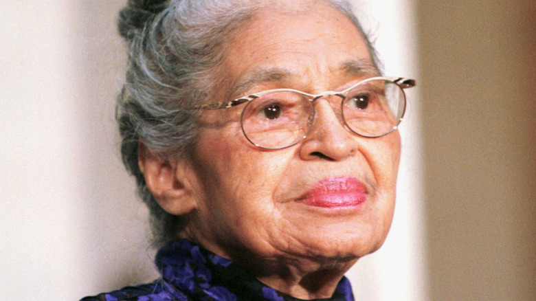 Rosa Parks in purple dress and glasses.