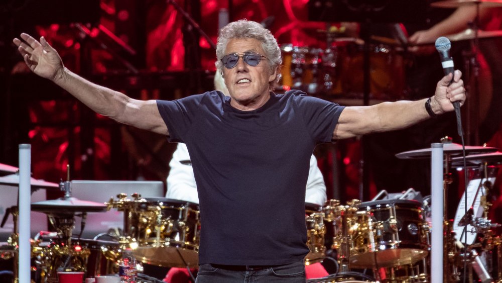 Roger Daltrey sunglasses arms wide on stage