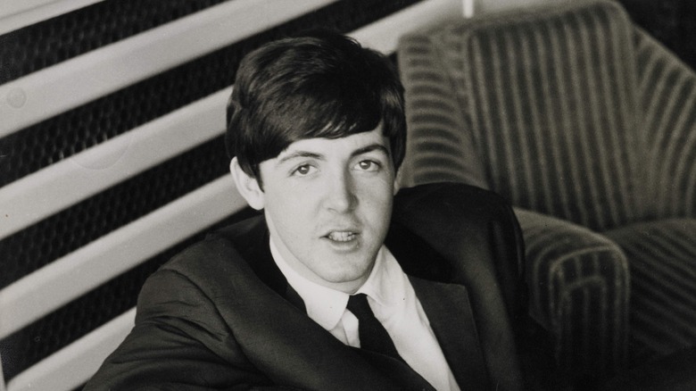 Paul McCartney on stage with bass in leather jacket