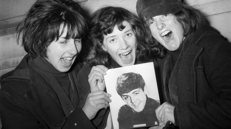 Teenage fans holding picture of Paul McCartney