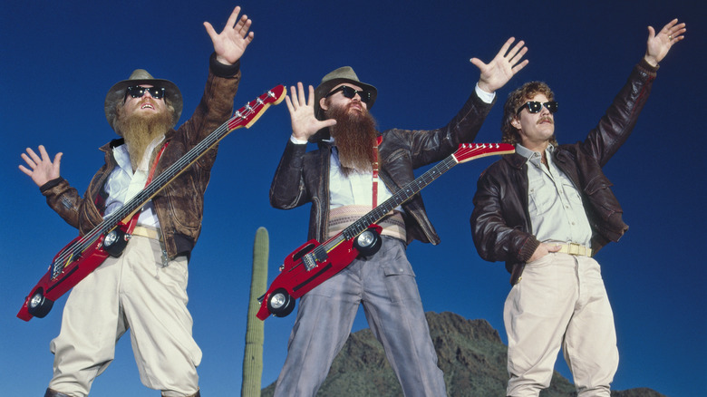 ZZ Top posing for band photo with hands in the air