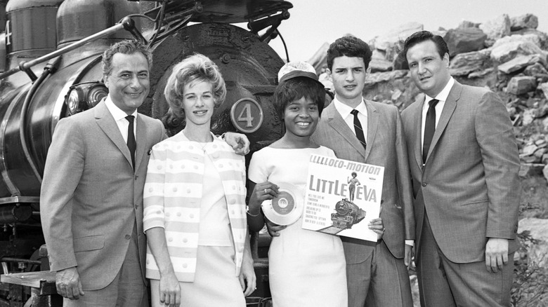Singer Little Eva Boyd standing near a train in photo op with Carole King and others