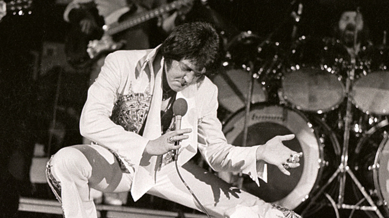 Elvis Presley performing onstage with microphone in one hand