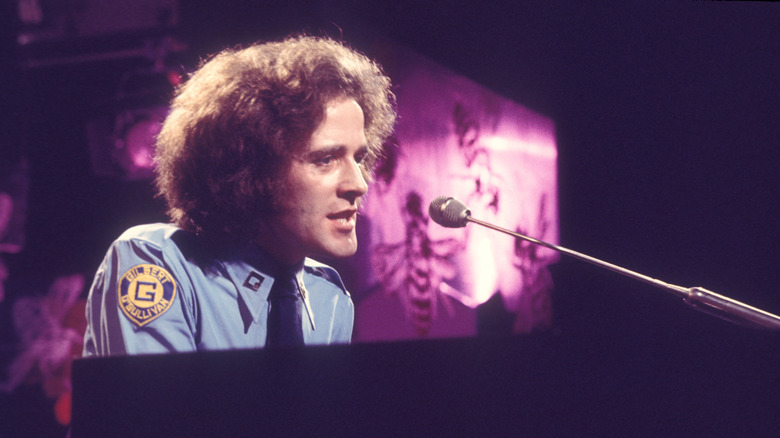 Gilbert O'Sullivan in profile playing piano onstage
