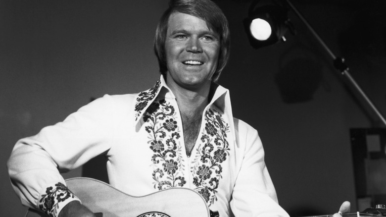 Glen Campbell smiling and playing guitar