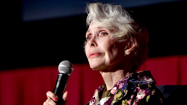 Barbara Rush floral dress holding mic
