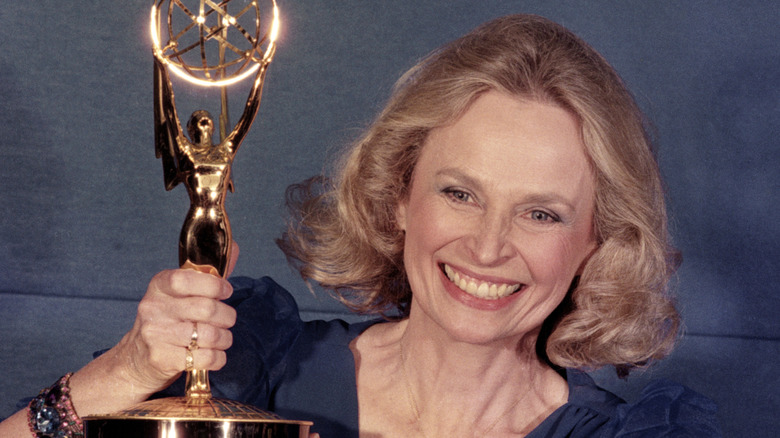 Bonnie Bartlett smiling and holding an Emmy award