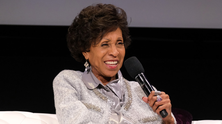 Marla Gibbs sat smiling holding mic