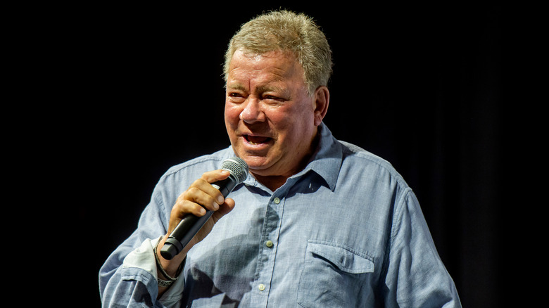 William Shatner speaking blue shirt