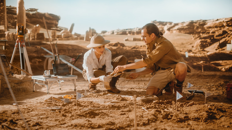 two archaeologists excavating artifacts