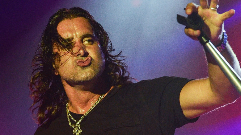 Scott Stapp pursing lips holding microphone stand