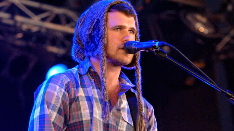 Jesse Lacey in wooly hat playing guitar and singing on stage