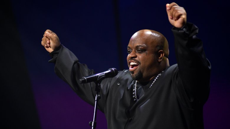 CeeLo Green in black shirt hands raised on stage