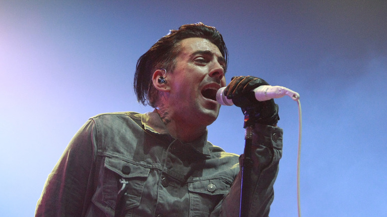 Ian Watkins on stage singing into microphone