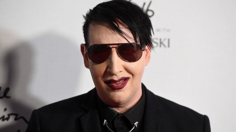 marilyn manson smiling in black suit and sunglasses at event