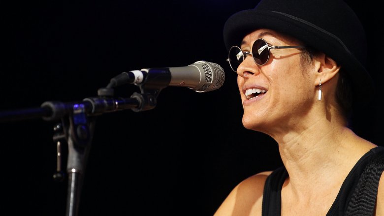 Michelle Shocked singling in hat and sunglasses on stage