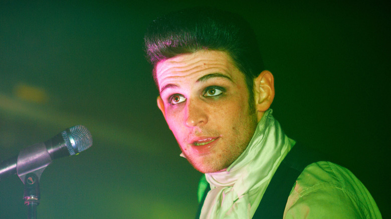 Wil Francis performing on stage lit in green