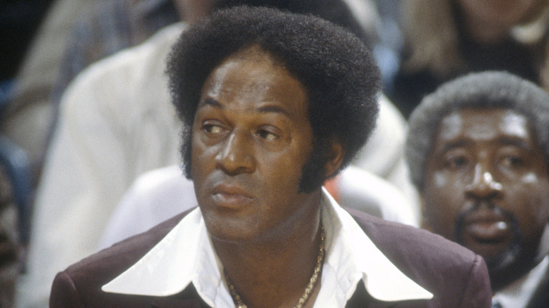 Elgin Baylor sitting brown suit necklace
