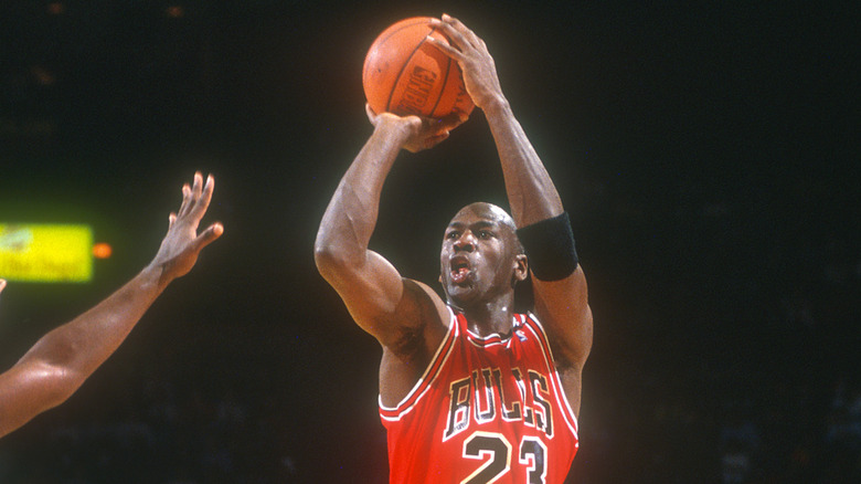 Michael Jordan taking jump shot Bulls shirt