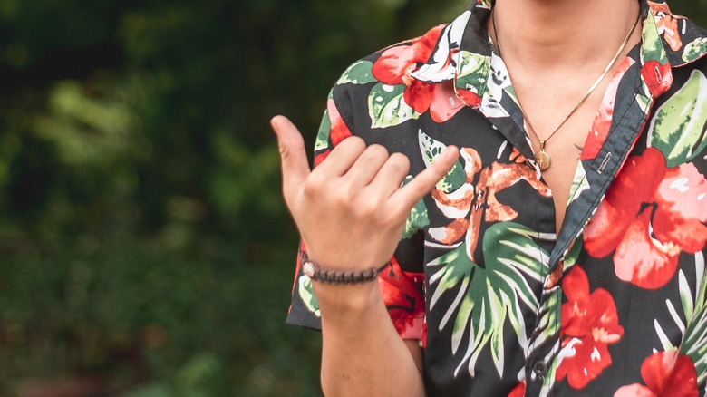 Surfer performing shaka hand gesture