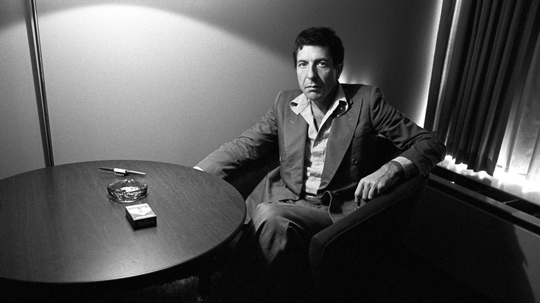 Leonard Cohen sits at a table