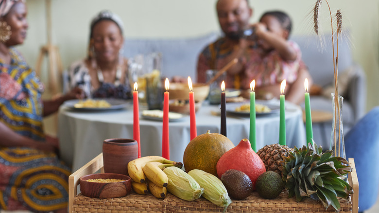 Family eats dinner behind Kwanzaa decorations