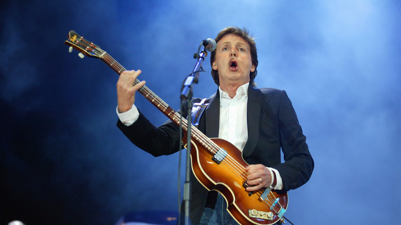 Paul McCartney on stage in suit performing with Hofner bass