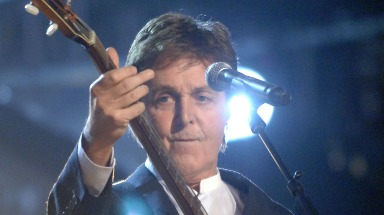 Paul McCartney on stage in suit performing with Hofner bassPaul McCartney on stage in suit performing with Hofner bass