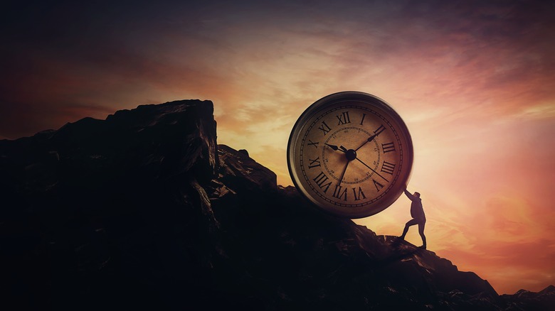 Man pushing a clock uphill