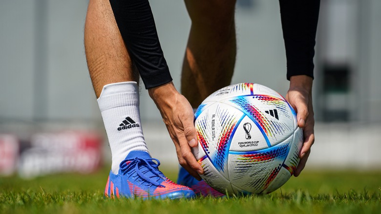 soccer player placing ball by foot