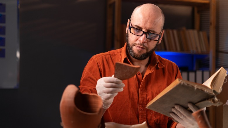 Archaeologist studying found artifacts