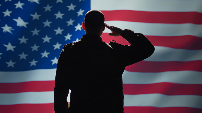 Military man saluting flag