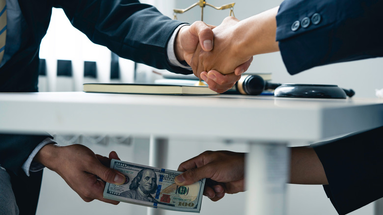 Businesspeople shaking on shady deal