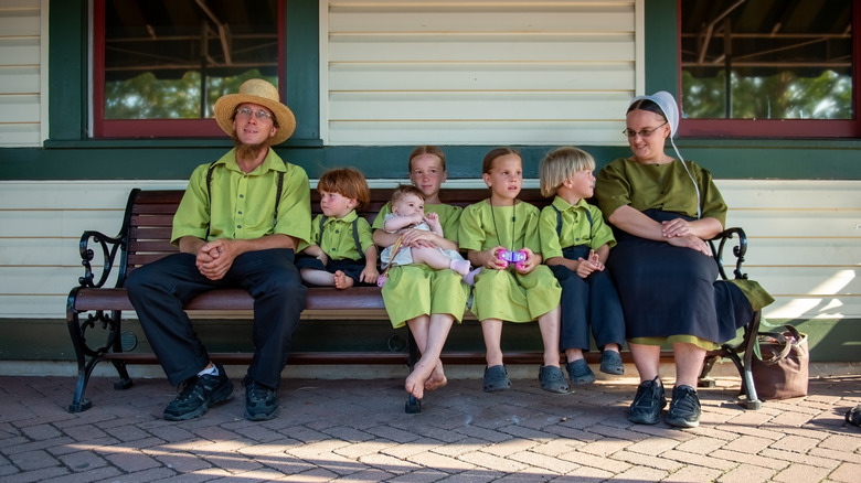 Amish family sitting on bench