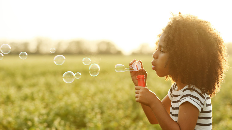 child blowing bubbles