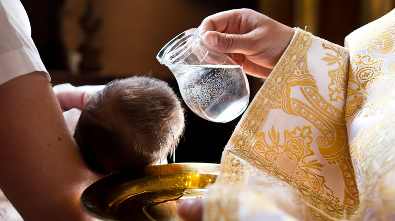 a priest baptizes an infant