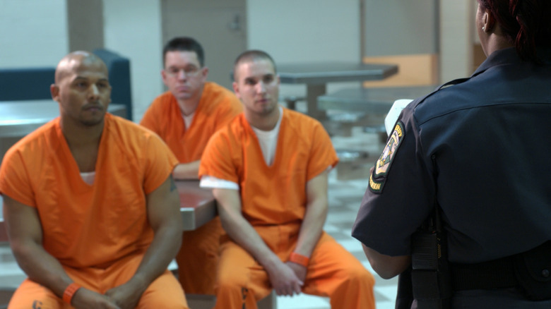 Prisoners seated with prison officer