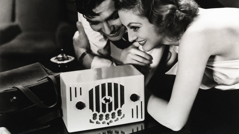 Clark Gable and Joan Crawford smiling over a radio