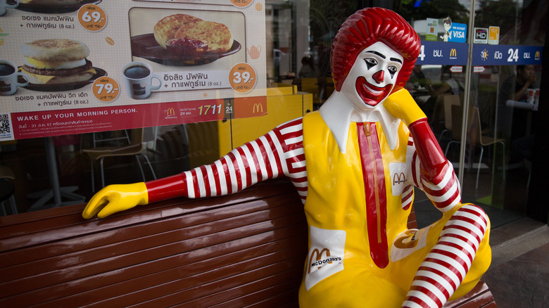 Ronald McDonald sitting alone on a bench