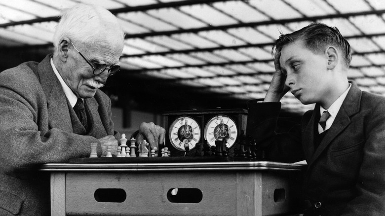 Old man and young boy playing chess