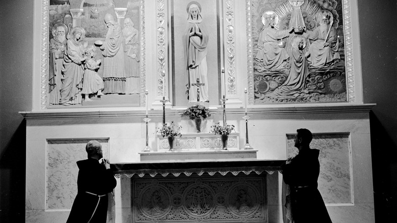 Monks kneeling at Mary statue
