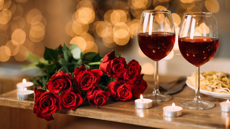 roses near glasses of red wine