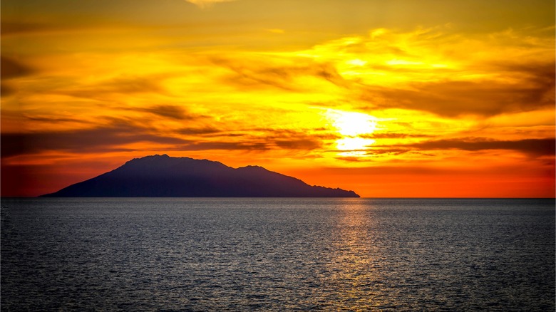 silhouette of an island at sunset on the ocean