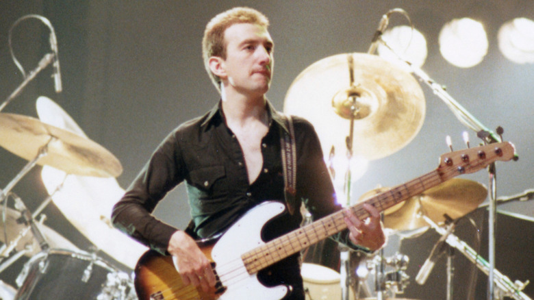 John Deacon playing bass onstage