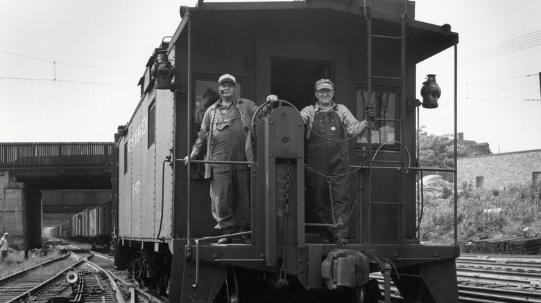 Train conductors ride a caboose