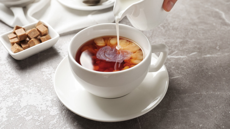 Pouring milk into tea