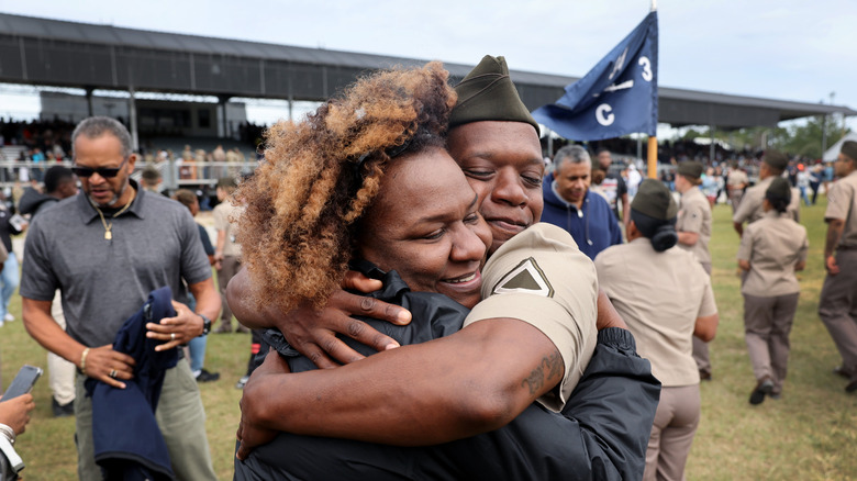 A newly graduated army cadet hugging a loved one